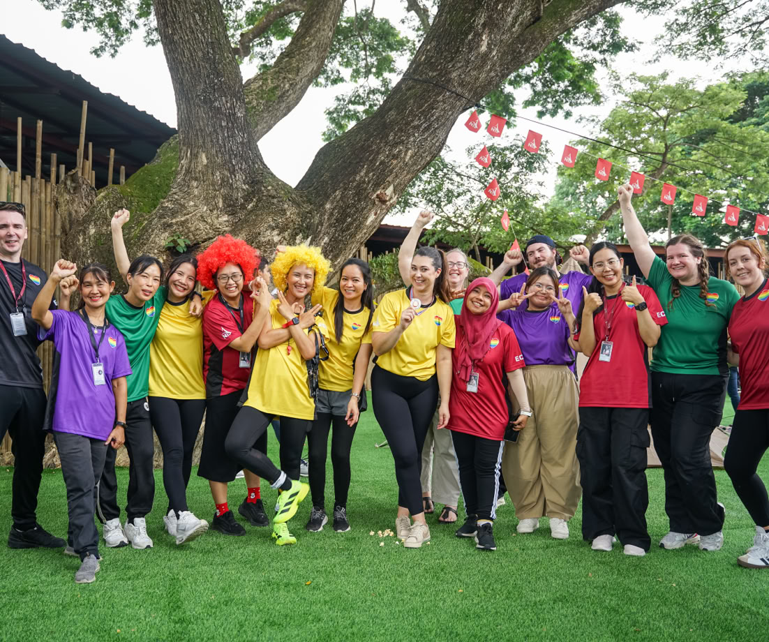 A mother assists her child with an apron in a creative art studio setting.