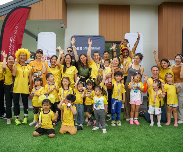 Two children and a teacher engaging in an eco-friendly lesson with a globe and wind turbine model.