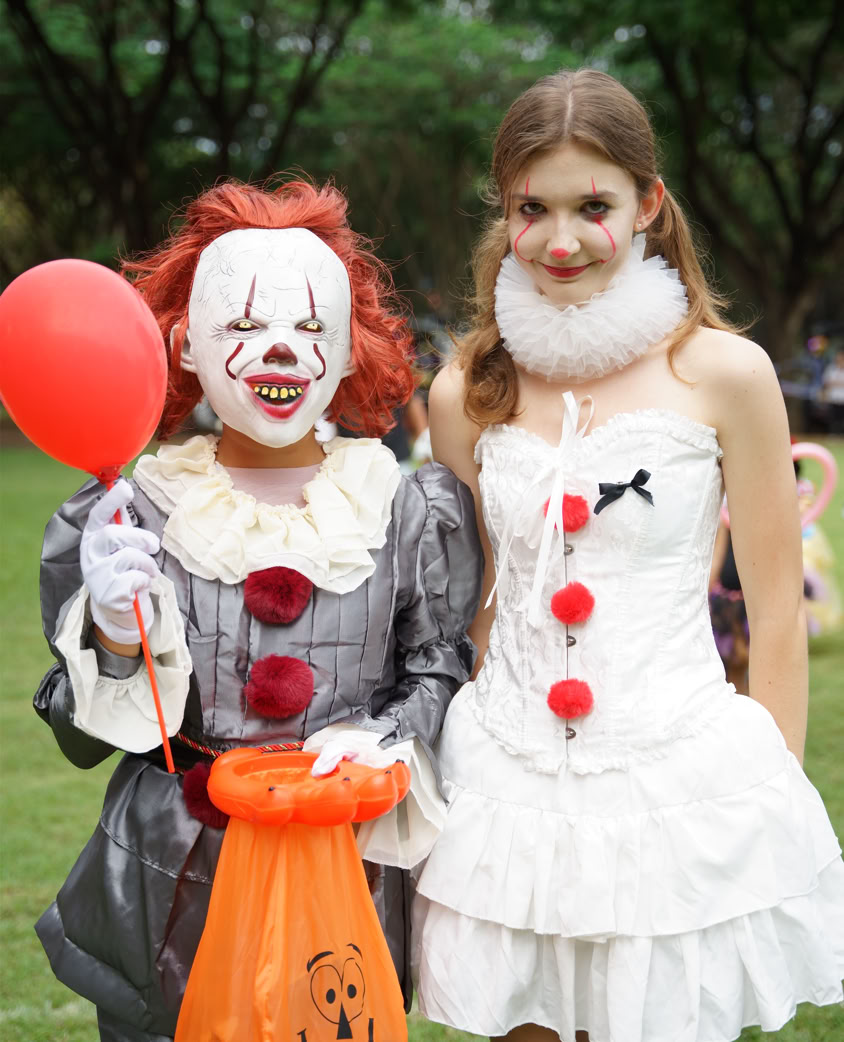 Happy diverse students in library raising hands, enjoying academic success.